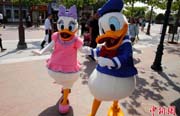 上海ディズニーのプレオープン、キャラクターと觸れ合う観光客