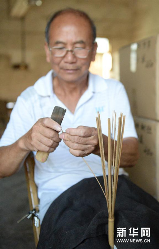 うちわの骨組みを作る広西チワン族自治區(qū)桂林市霊川県のうちわ職人?黃碩夫さん（7月6日撮影）。