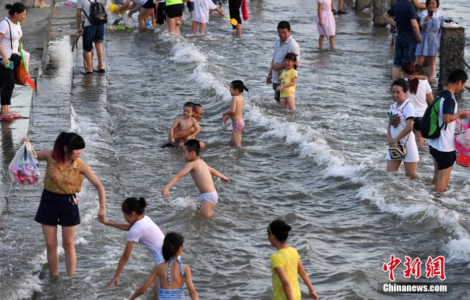 猛暑が続く廈門(mén)市、市民たちは海辺で水遊び