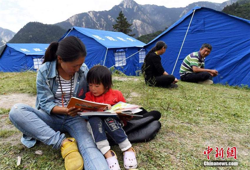 九寨溝景勝地荷葉寨のテント內(nèi)で読書を読む人々（8月12日、撮影?安源）