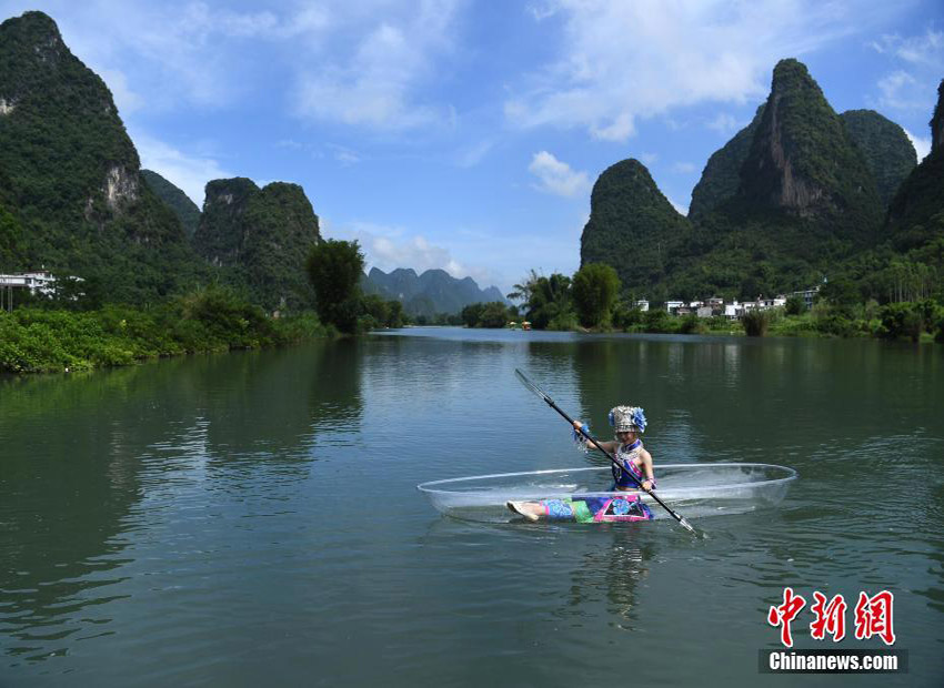 透明なボートの上で絵畫のような景色を堪能する少數(shù)民族の若者たち　桂林