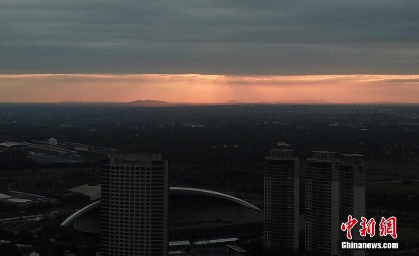 平行に並ぶ夕焼けと黒い雲(yún)　江蘇省揚(yáng)州市の上空に「一線天」出現(xiàn)