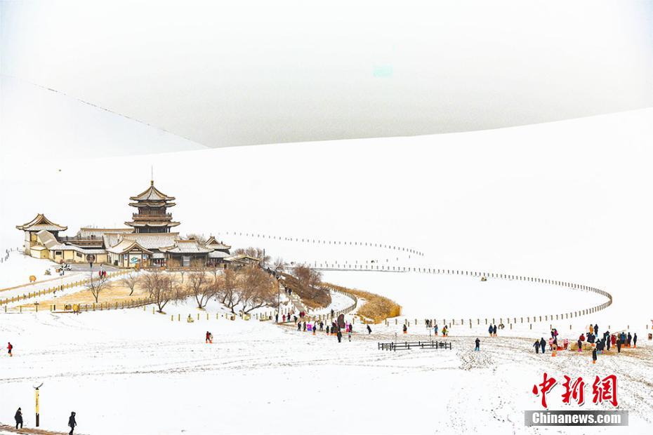 有名な鳴沙山?月牙泉景勝地も真っ白い雪に覆われ、普段とはひと味違う雪のシルクロードを見に、大勢の観光客が訪れた。（撮影?王斌銀）