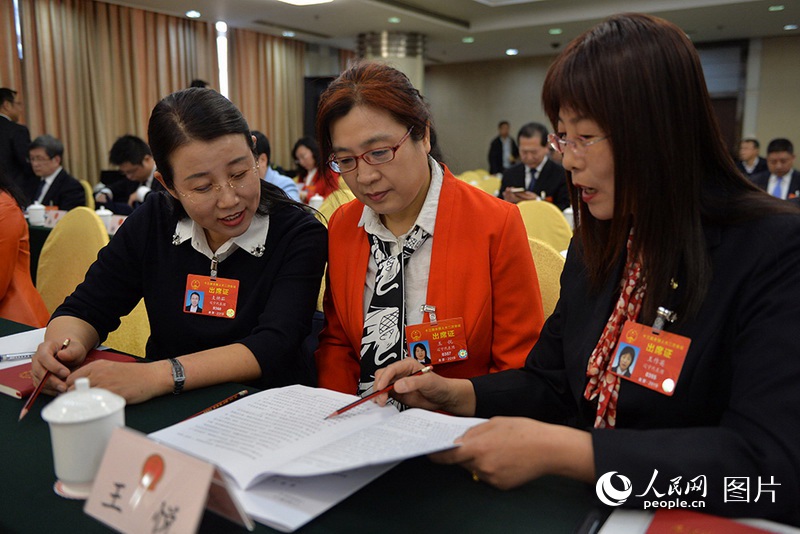 3月5日、遼寧代表団全體會(huì)議で、女性の代表が政府活動(dòng)報(bào)告について意見を交換していた。（撮影：翁奇羽）