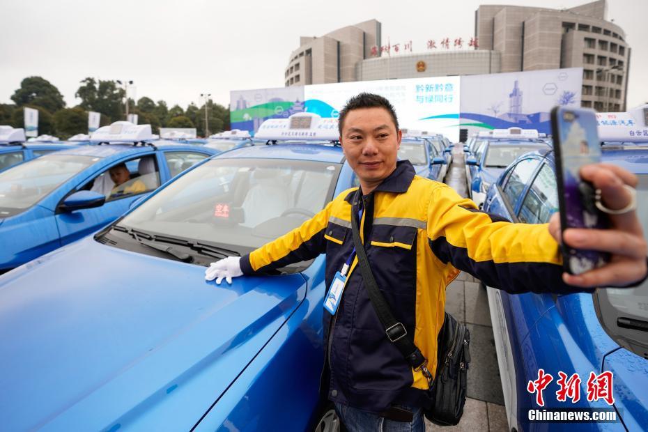 引き渡しセレモニーでメタノール車タクシーと記念撮影するタクシー運転手（撮影?賀俊怡）。