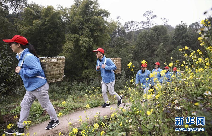 醫(yī)療機器の入ったかごを背負って山道を歩く重慶市九龍坡區(qū)陶家鎮(zhèn)衛(wèi)生院の「かごを背負ったお醫(yī)者さん」（2月20日撮影?蘭紅光）。