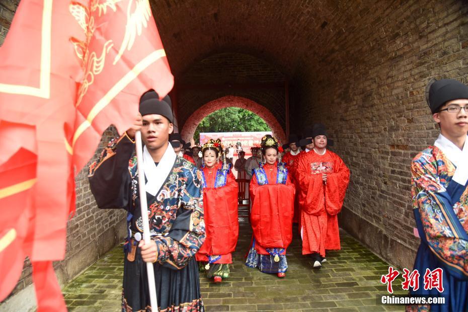 広西壯（チワン）族自治區(qū)柳州市の明代に建設(shè)された東門で結(jié)婚式を挙げるカップル6組（撮影?王以照）。