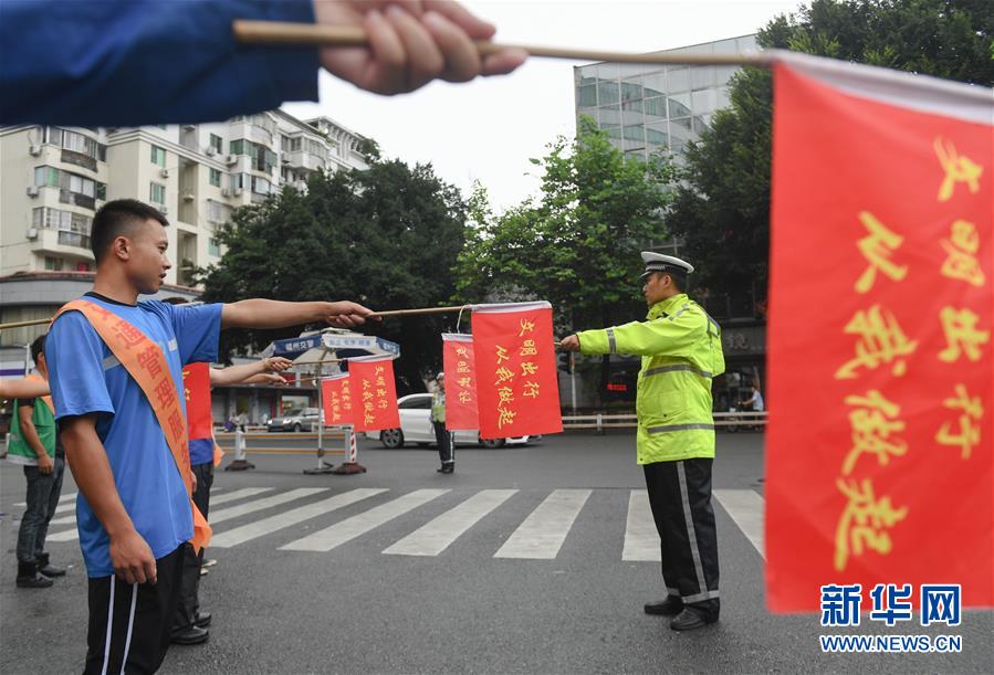 7月11日、福建省福州市で配達(dá)員に交通整理の誘導(dǎo)サインの手本を示す警察官（撮影?宋為偉）。