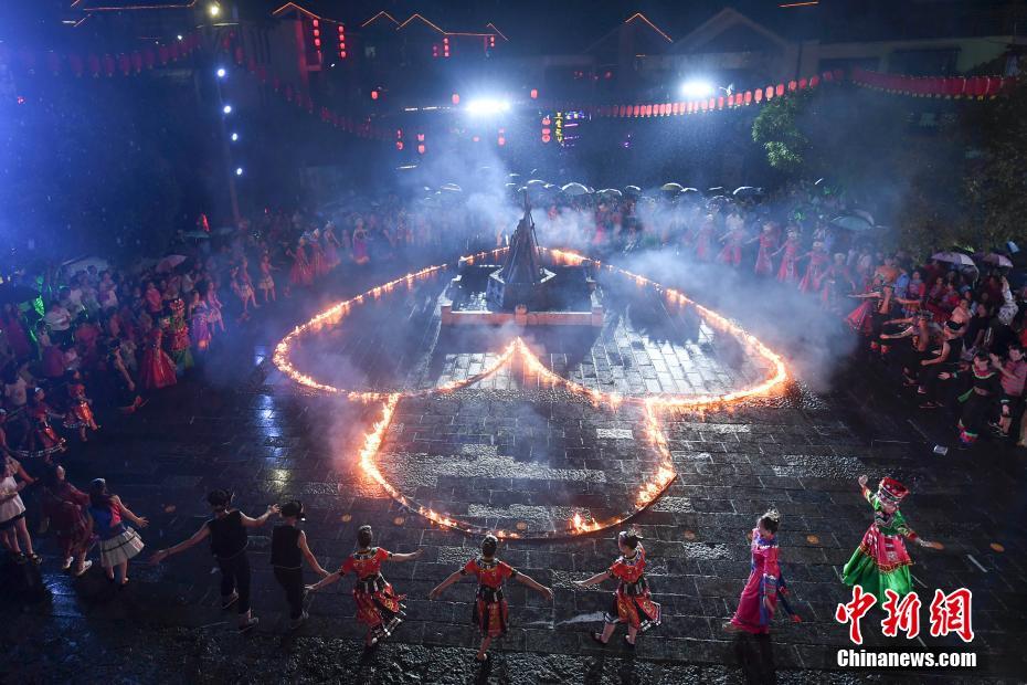 張家界で少數(shù)民族の男女が巨大「同心鎖」に點火し七夕祝う　湖南省