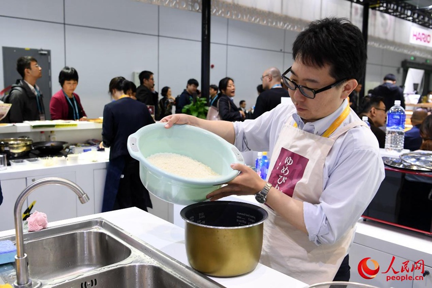 研いだ米を炊飯器に移す石山さん。