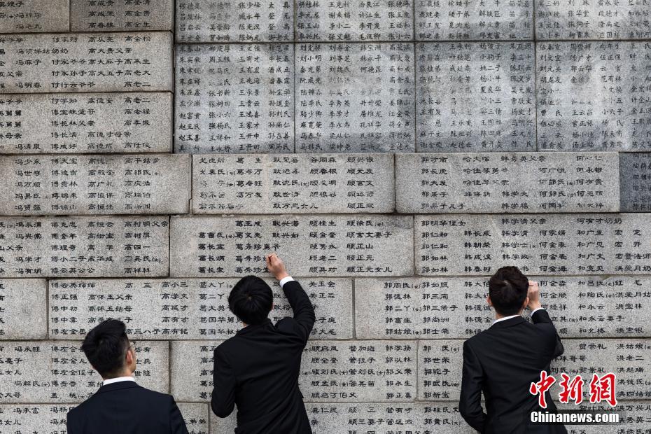 中國(guó)侵略日本軍南京大虐殺の犠牲者名が刻まれた壁で、犠牲者の名前を一つ一つ「書(shū)き直し」ていく南京審計(jì)大學(xué)のボランティア（撮影?泱波）。 