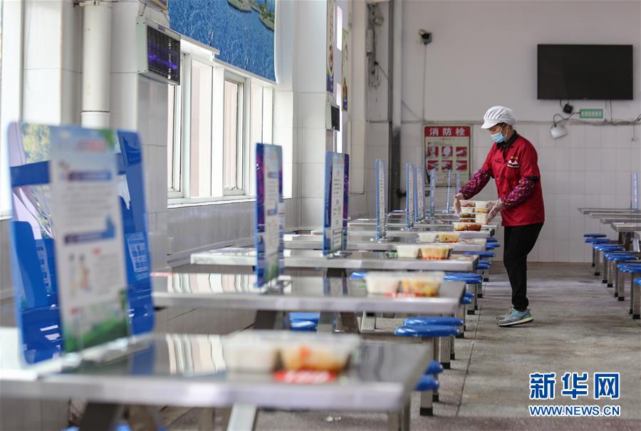 4月7日、湖南省永州市零陵區(qū)柳子中高一貫校の學(xué)生食堂で、距離を取って食事ができるよう生徒の弁當(dāng)を配膳する職員（撮影?潘愛民）。