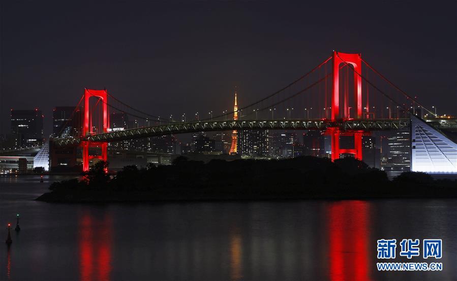 「東京アラート」発動にともない、ライトアップの色が虹色から赤色に変わったレインボーブリッジ（寫真提供?新華社、共同通信社）。