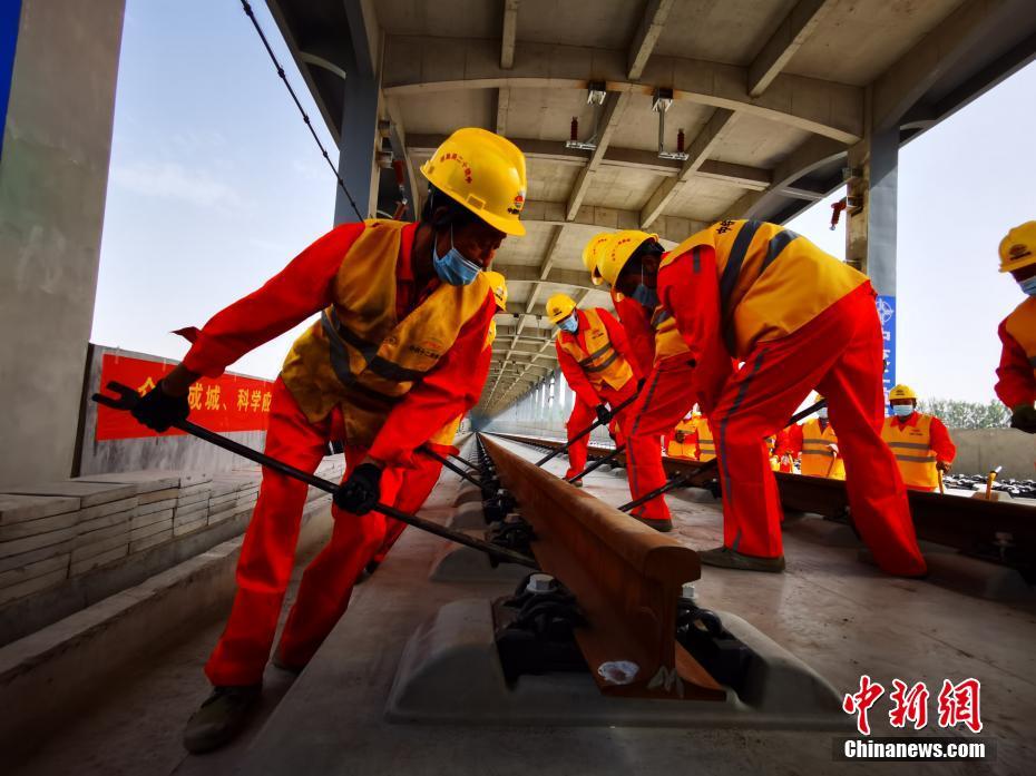 北京―雄安都市間鉄道（河北區(qū)間）レール敷設(shè)工事現(xiàn)場(chǎng)でレール敷設(shè)を進(jìn)める作業(yè)員（撮影?孫麗萍）。