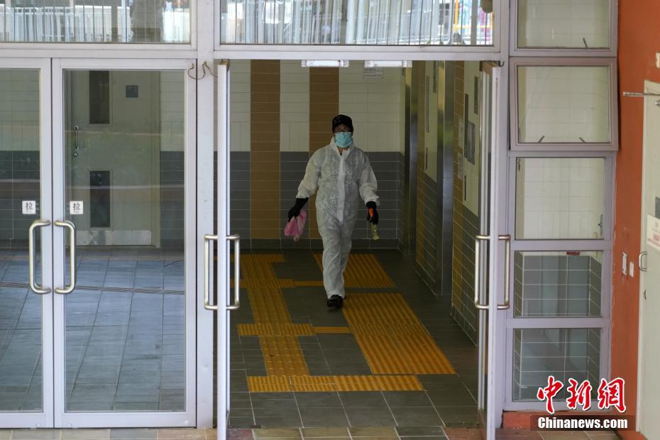 7月11日、防護(hù)服を著用して香港地區(qū)沙田にある水泉澳邨明泉樓の內(nèi)部を消毒する作業(yè)員（撮影?張煒）。