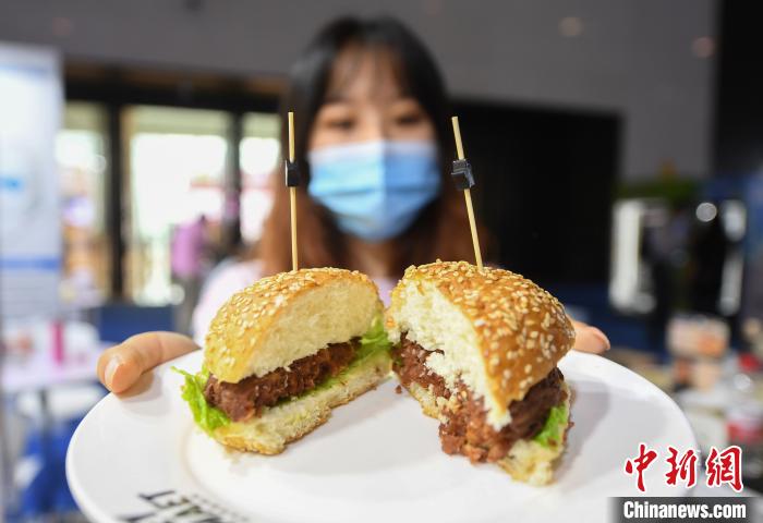 人工肉で作ったハンバーグを展示するスタッフ（撮影?王剛）。