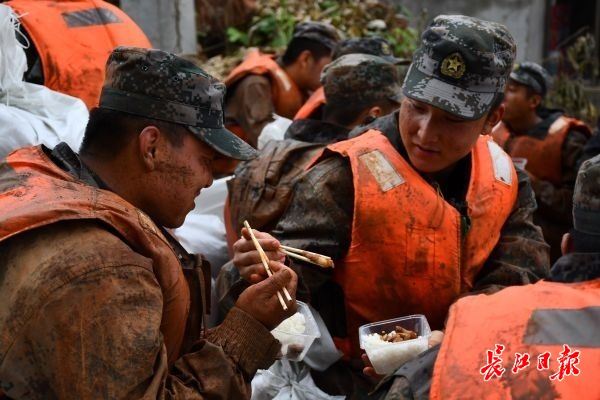 堤防復(fù)舊作業(yè)8時間！全身泥まみれで食事をとる兵士らに敬意を！　湖北省 