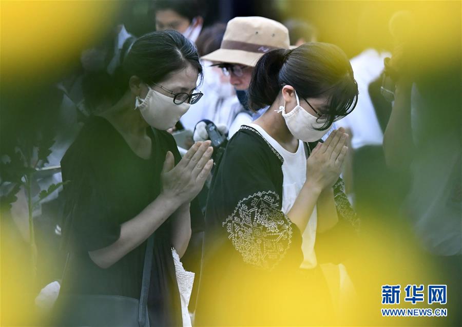 8月6日、広島で行われた平和記念式典開始前に、両手を合わせ平和の祈りをささげる人々（新華社/共同通信社）。