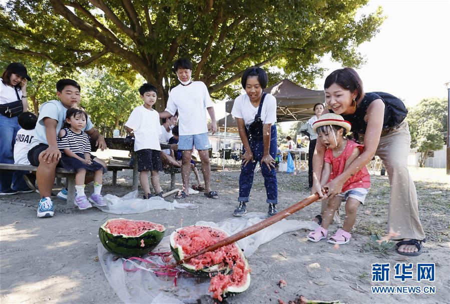 8月11日、東京?葛西臨海公園で、スイカ割りを楽しむ子供と保護(hù)者（寫真提供?新華社、共同通信社）。