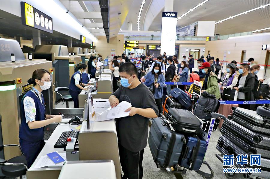 9月21日、海南航空が運(yùn)航する英國行チャーター機(jī)HU7953便に搭乗するため、重慶江北國際空港ターミナルビルの指定エリアでチェックイン手続きをする留學(xué)生たち（畫像提供?重慶空港集団）。