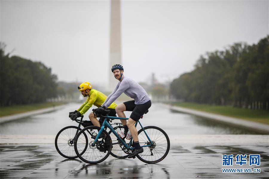 10月12日、米國の首都ワシントンで、ワシントン記念塔の近くを自転車で通り過ぎる市民（撮影?沈霆）。