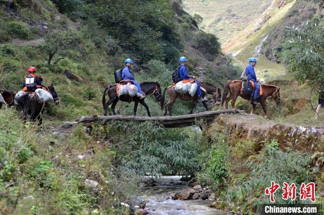 馬に跨り木の橋を渡り無人區(qū)に入る4人の電気保安管理員（撮影?張浪）。