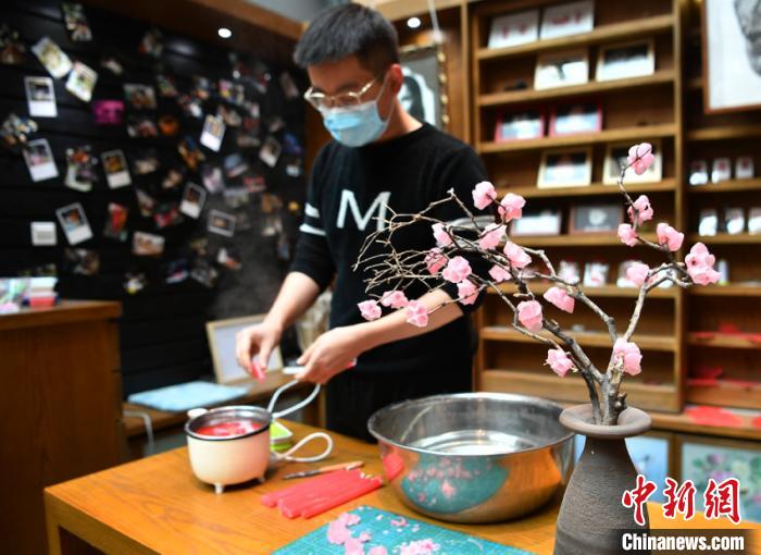 12月4日、吉林省長春市で、ろう細工の梅の花を制作する馬春潮さん。