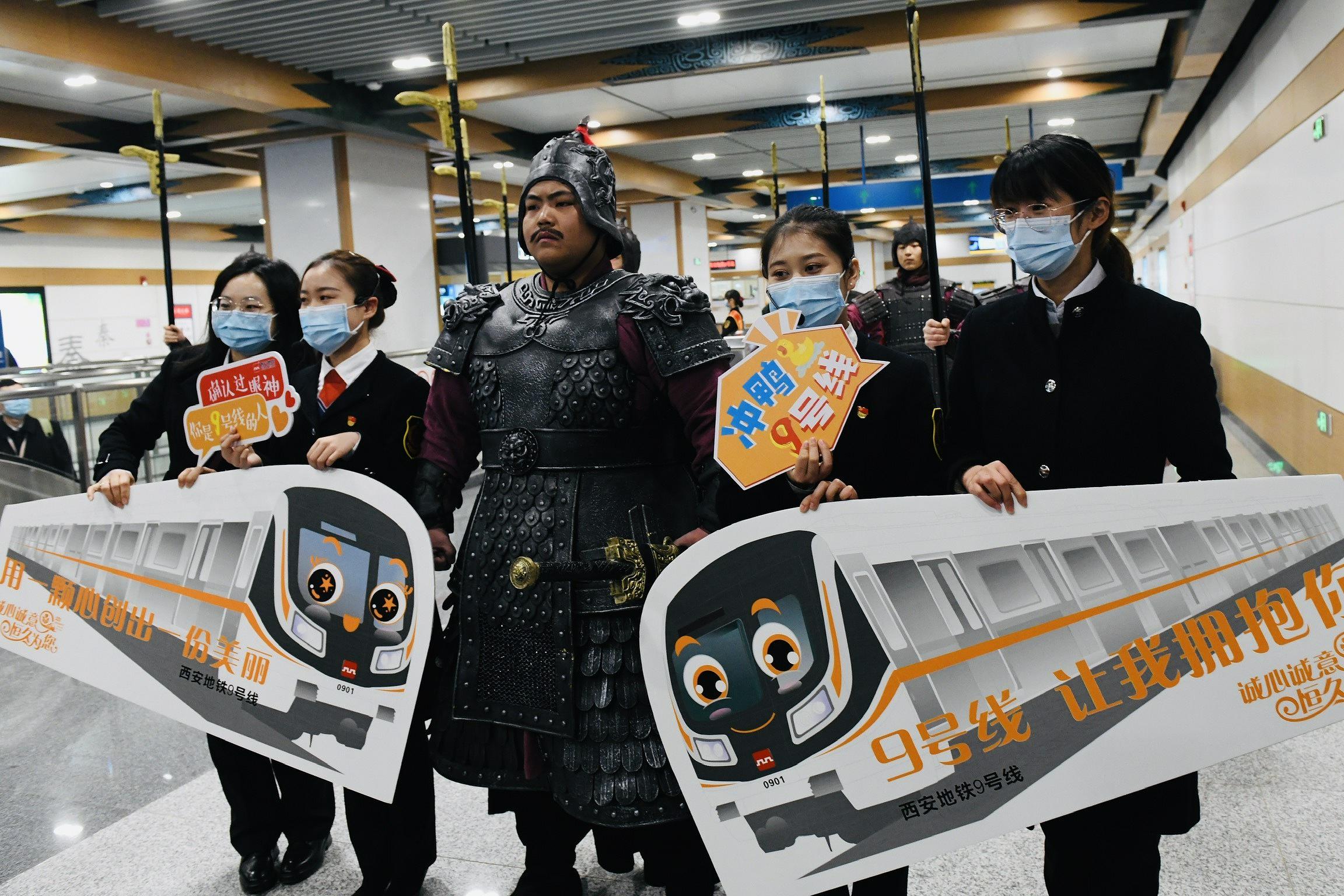 12月9日、秦陵西駅で、地下鉄アテンダントたちと記念撮影する「兵馬俑」（寫真著作権はCFP視覚中國が所有のため転載禁止）。