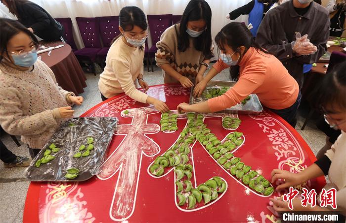 包んだ餃子で文字を作る大學(xué)生（撮影?泱波）。