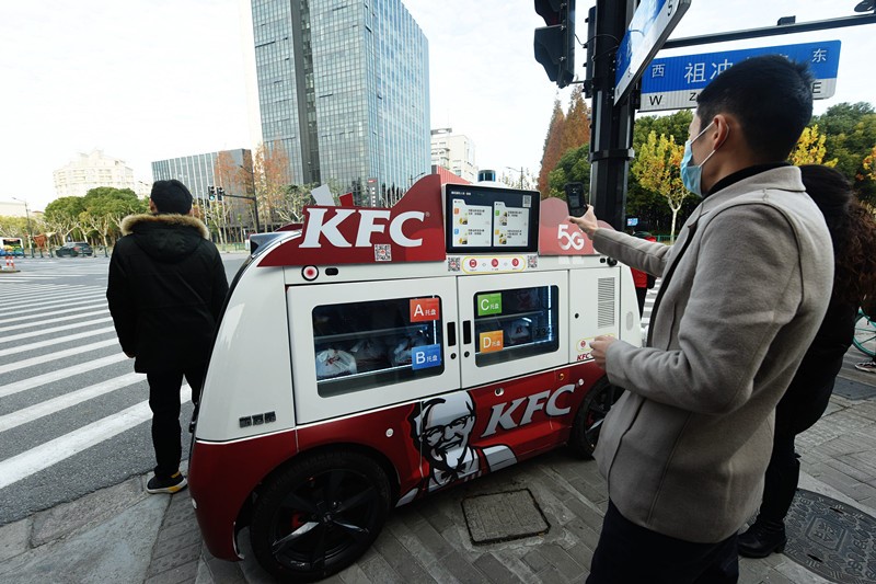 2020年12月17日、上海の街頭に置かれた5Gスマート無人朝食車でコードをスキャンし、朝食を購入する市民。竜巍/人民図片