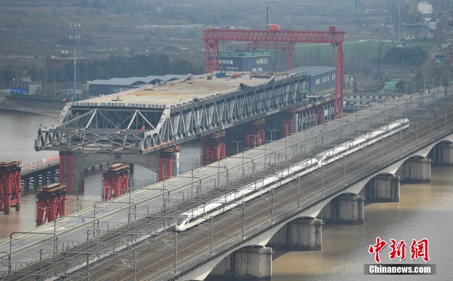 3月4日、銭塘江に新たに建設(shè)されている大橋の傍を走り抜ける高速鉄道（撮影?王剛）。