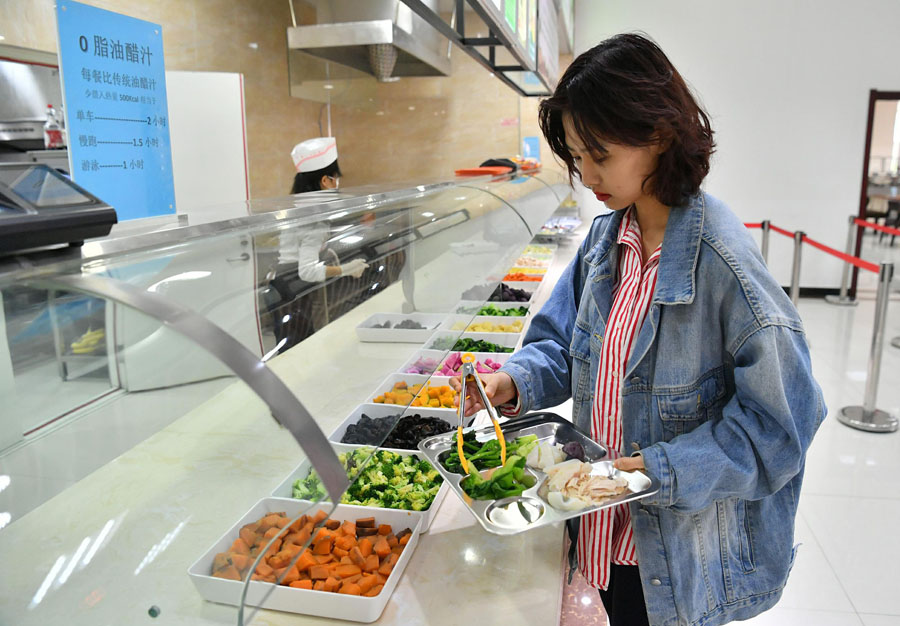 4月1日、長春中醫(yī)薬大學の食堂で、ヘルシーな料理を選ぶ女子大生（寫真著作権はCFP視覚中國が所有のため転載禁止）。