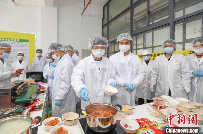 「ピリ辛タニシ麺」を作る辣條専攻クラスとタニシ麺學(xué)院の教員?學(xué)生（撮影?楊華峰）。