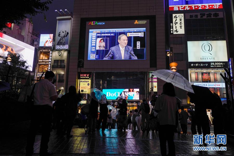 7月8日、日本の東京で、菅義偉首相が緊急事態(tài)宣言の発令を表明した記者會(huì)見の様子を映し出す街頭スクリーン。