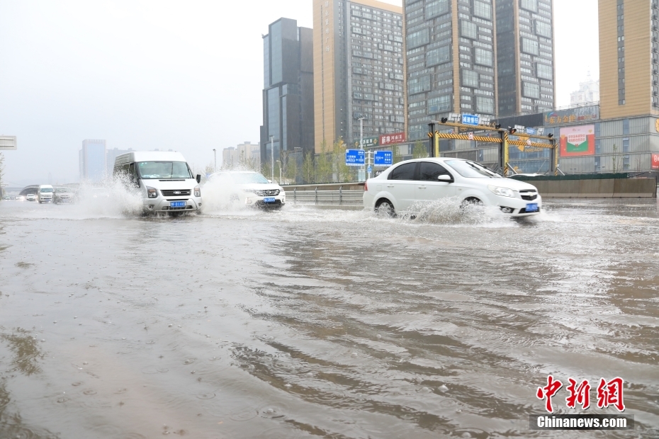 鄭州市市街地で、冠水した道路を走行する車両（撮影?闞力）。