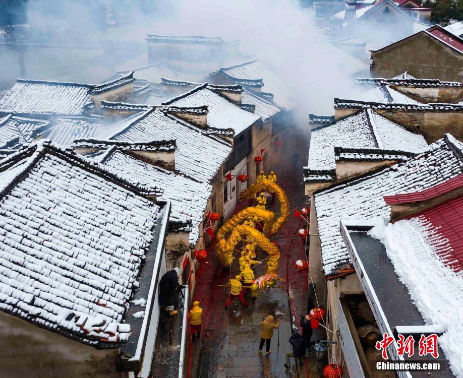 安徽省寧國市胡楽鎮(zhèn)で、雪が積もった歴史ある通りを胡楽司龍燈チームが元宵節(jié)の龍の舞いを披露しながらねり歩く様子（2月14日撮影?李暁紅）。