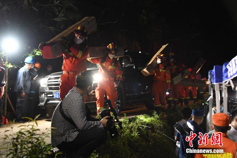 3月21日夜、事故機の墜落現(xiàn)場で、臨時指揮部を立ち上げた救助チーム。現(xiàn)地の電力供給當局は、野外用臨時電線を架設して救助活動をサポート。消防隊員が運搬した救援物資も事故現(xiàn)場に到著（撮影?何華文）。