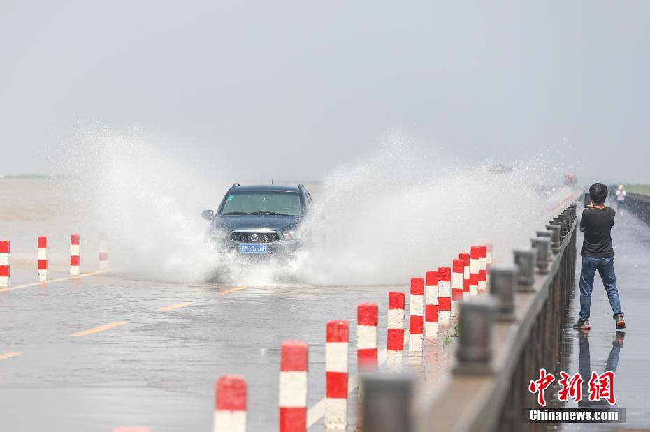 大きな水しぶきをあげながら「水上道路」を走行する自動(dòng)車(chē)（撮影?劉力鑫）。