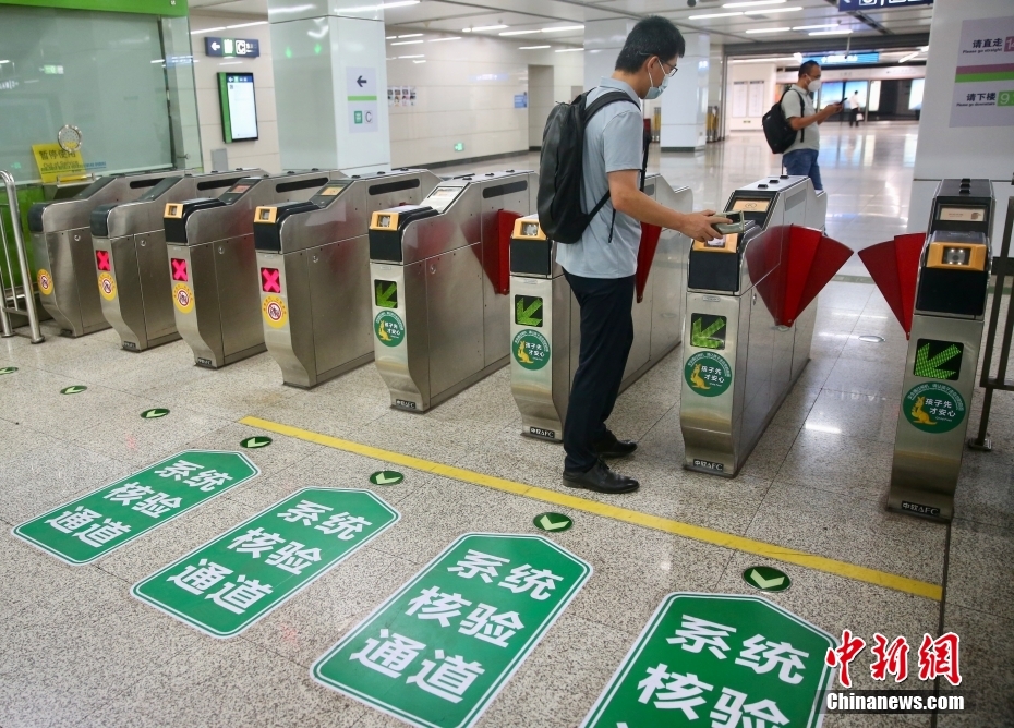 北京地下鉄七里莊駅で、乗車(chē)QRコードをかざして改札を通る乗客（6月9日撮影?易海菲）。