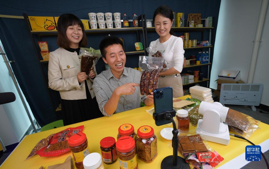 貴州省順義市綏陽県農(nóng)産物流通センターで、ライブコマースを通じてソーセージを販売する蔣栄慶さん（寫真中）とスタッフ（6月12日撮影?楊楹）。