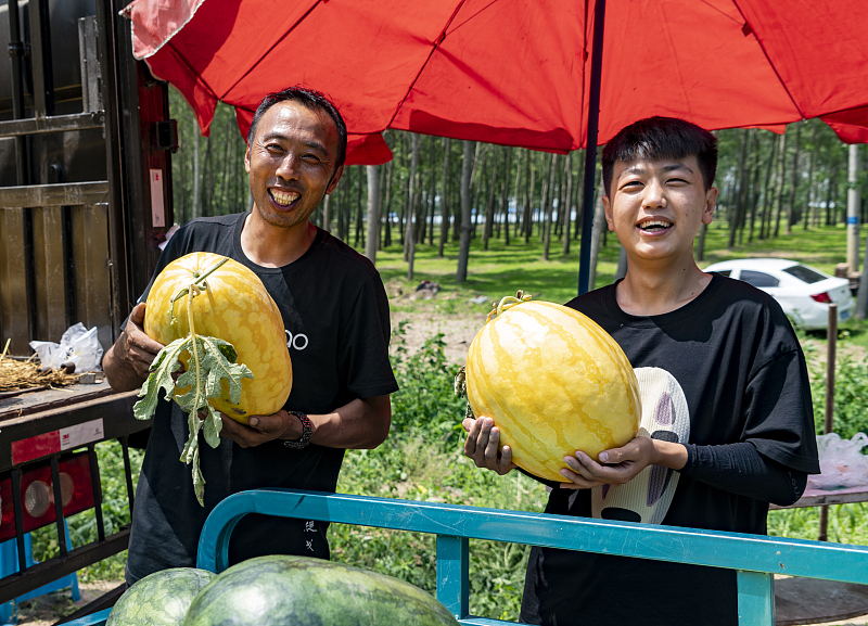 黃色いスイカを見せる農(nóng)家（寫真著作権はCFP視覚中國が所有のため転載禁止）。