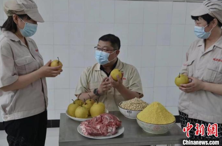 羊羔酒の原料となるもち粟、羊肉、雪花梨、アーモンドなどを選ぶ技術(shù)スタッフ（撮影?李明発）。