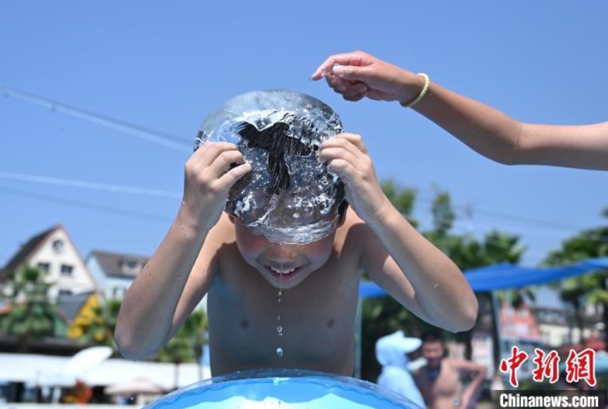 暑気払いに氷と戯れる子供（撮影?陳超）。