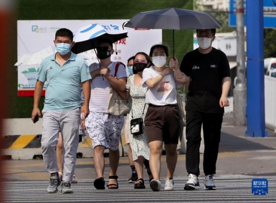 7月10日、炎天下の中、上海市閔行區(qū)內(nèi)を歩く市民。