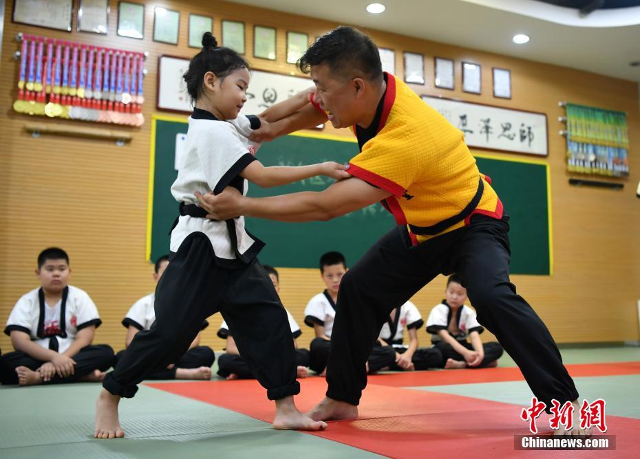 8月3日、河北省石家荘市にあるスポーツトレーニング施設(shè)で、組み手のやり方を子供に指導(dǎo)する「カンフー格闘技」伝承者の楊興コーチ（寫真右、撮影?翟羽佳）。