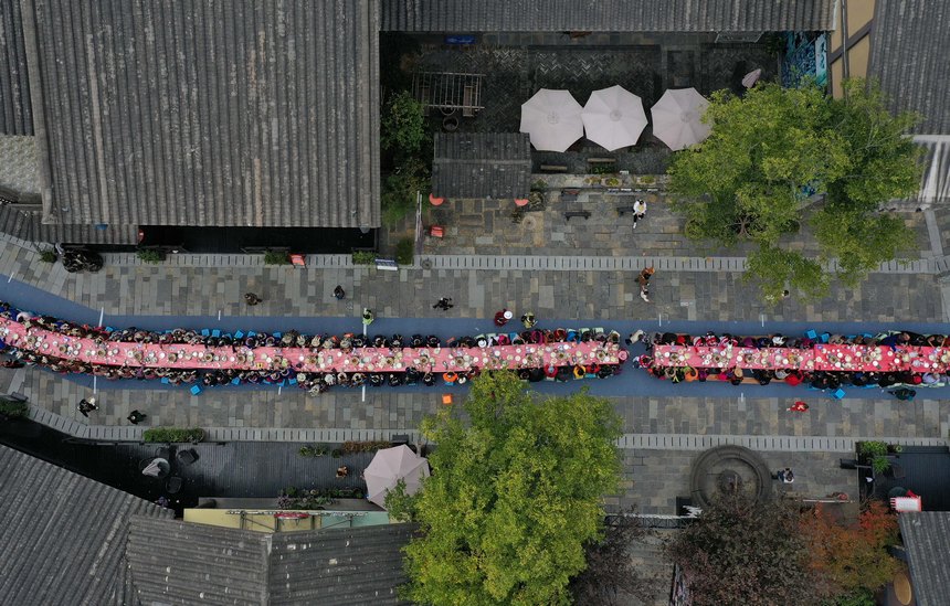 長(zhǎng)いテーブルに料理を並べ、苗族の新年祝う宴　貴州省丹寨