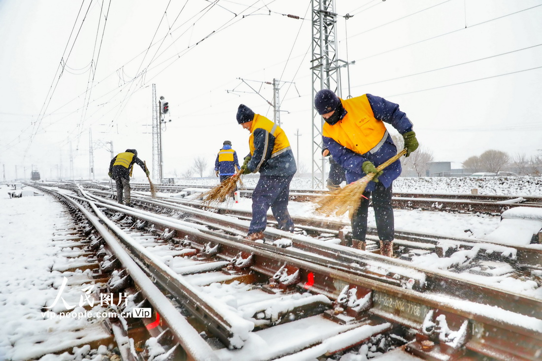 鉄道輸送の安全性と円滑性を確保するため、分岐器の除雪作業(yè)を行う中國(guó)鉄路瀋陽(yáng)局集団公司の職員（11月12日撮影?李季春/寫(xiě)真著作権は人民図片が所有のため転載禁止）。