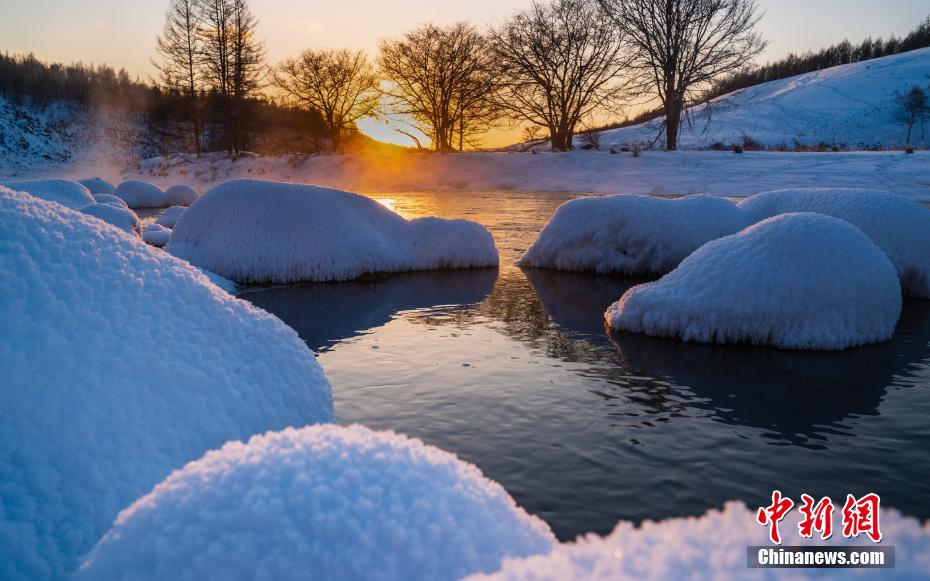 「凍らない川」に浮かぶ、真っ白で餅のようにこんもりとした雪の塊（撮影?李明）。