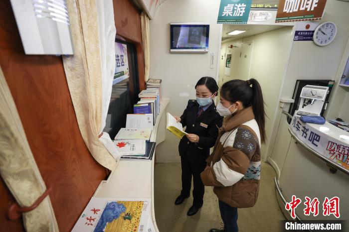 「列車內(nèi)ブックカフェ」で、學(xué)生に書籍を紹介する貴陽旅客輸送區(qū)間の職員?牛婧さん（撮影?瞿宏倫）。