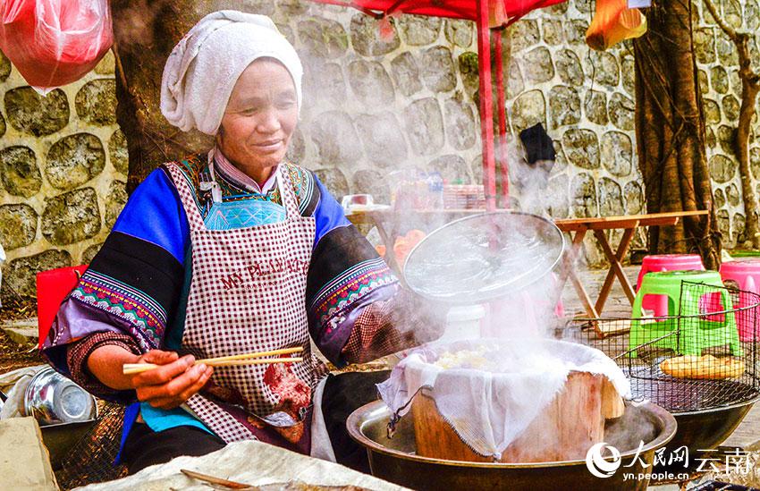 多依河のほとりで布依族の特色豊かなグルメ「花米飯」を作り、販売する布依族の女性（撮影?劉怡）。